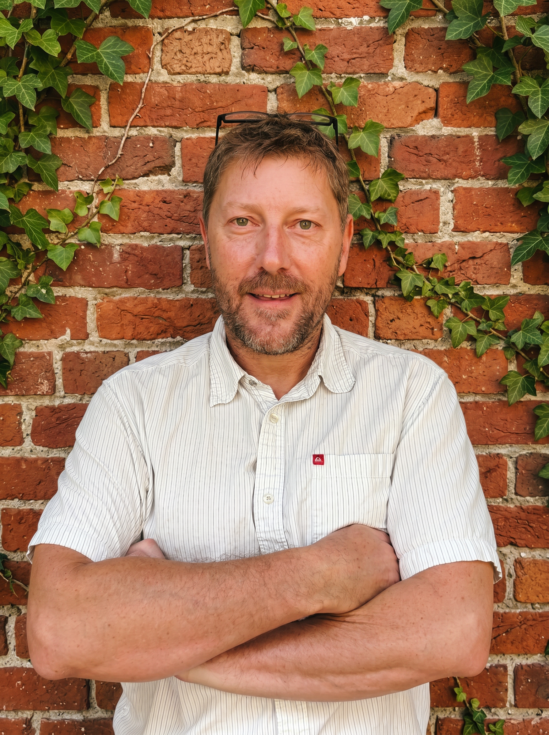 Dr. Greg Nigh in front of an ivy-covered brick wall